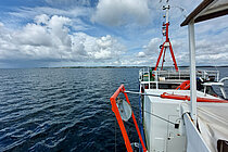 Der Bug eines Schiffes auf dem Wasser, dicht unter der Küste